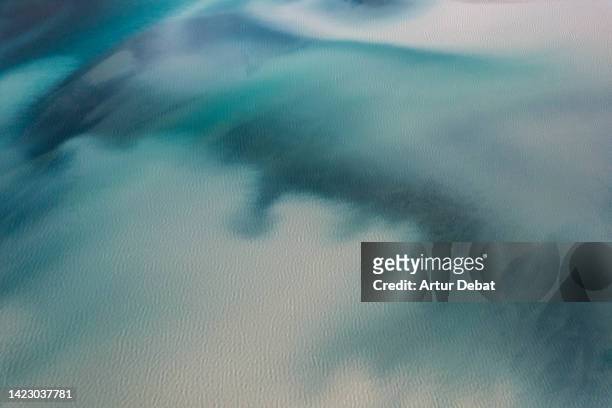 drone picture of blue glacier lagoon with sediments mixing in iceland. - drone images stock-fotos und bilder
