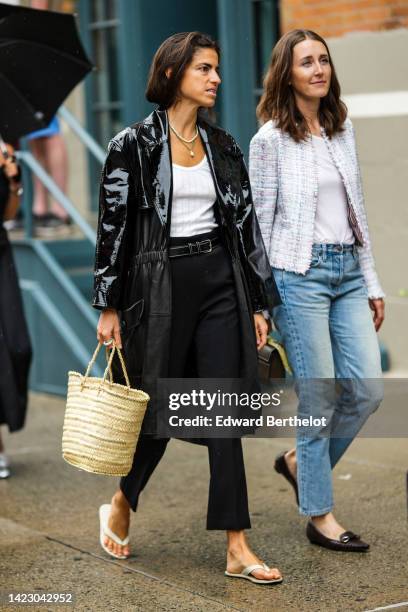 Guest wears a black shiny varnished leather long coat, a white ribbed V-neck t-shirt, a white pearls necklace, a green pearls pendant necklace, a...