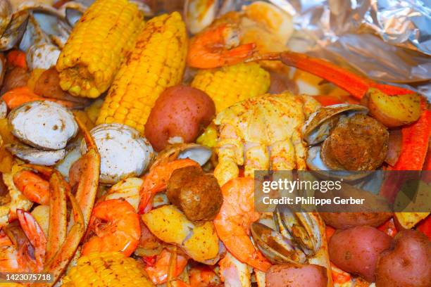 southern style seafood boil - crab legs stock pictures, royalty-free photos & images