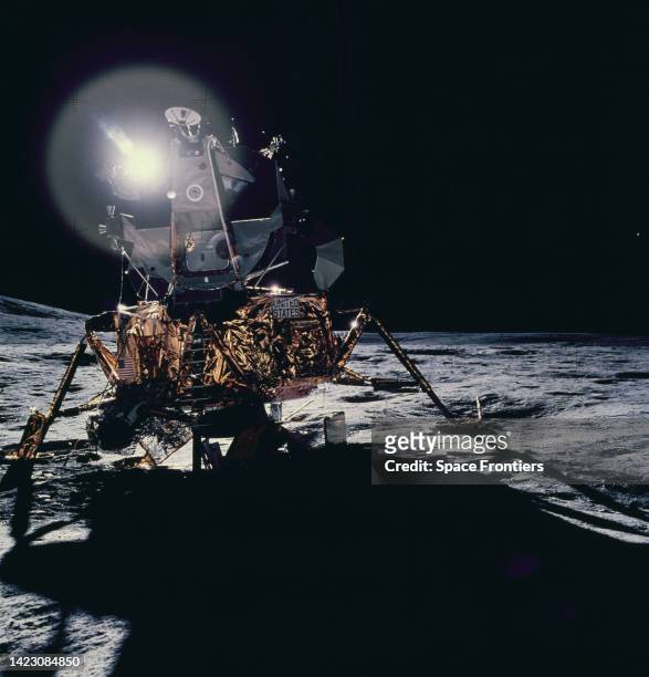 Front view of the Apollo 14 Lunar Module , which reflects a circular flare caused by the Sun, as seen by the two moon-exploring crew men of the...