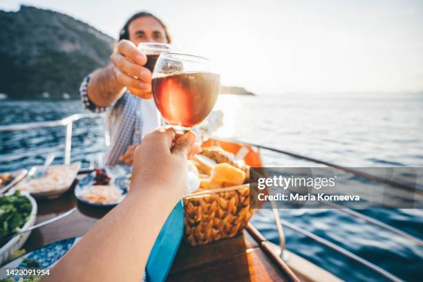 friend drinking wine on the yacht at  sunset. toasting on a yacht. - romantic picnic stockfoto's en -beelden