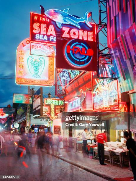 busy street lit with neon signs - pattaya stock-fotos und bilder