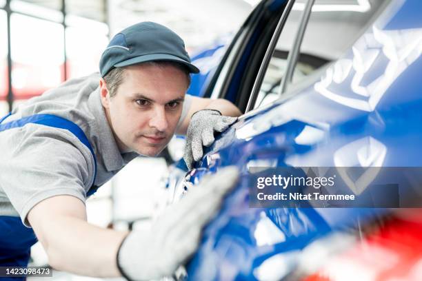 optimize the quality of every paint correction and ceramic coating. a male technician is inspecting a car's rear quarter panel outer surface during paint correction before and after applying the ceramic coating in an auto repair shop. - auto detailing stock pictures, royalty-free photos & images