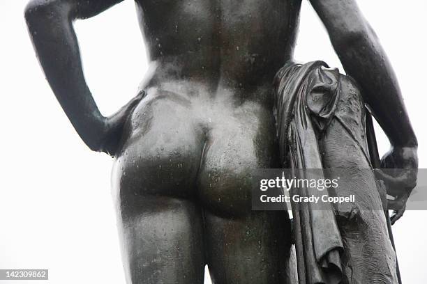 rear detail of statue of male figure - male buttocks stockfoto's en -beelden