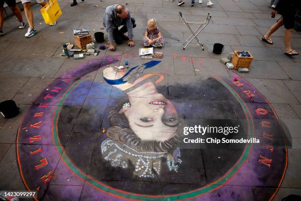 Three-year-old Violet Williams watches as chalk artist Julian Beever works on a portrait of Queen Elizabeth II on the sidewalk near Trafalgar Square...