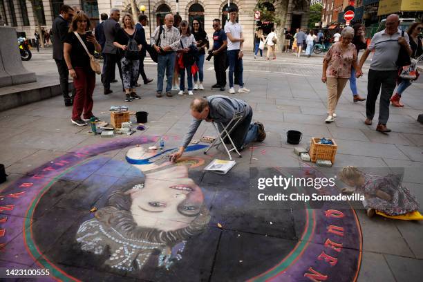 Three-year-old Violet Williams makes her own contribution to artist Julian Beever's chalk portrait of Queen Elizabeth II on the sidewalk near...