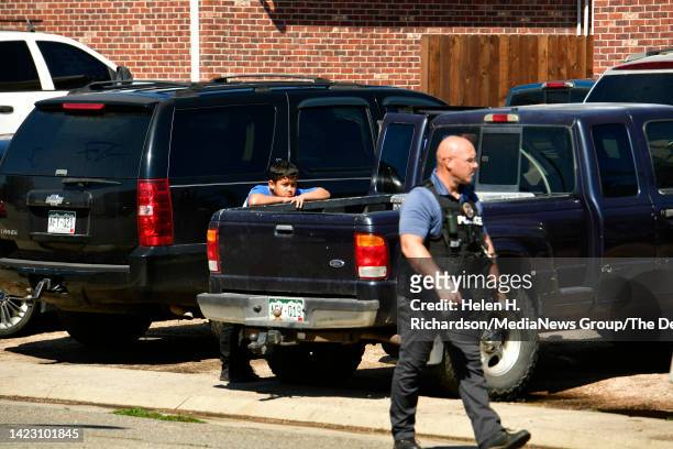 Resident Luis Olvera watches as an Arvada police officer investigates the scene of a shooting where an officer was killed in the 6700 block of West...