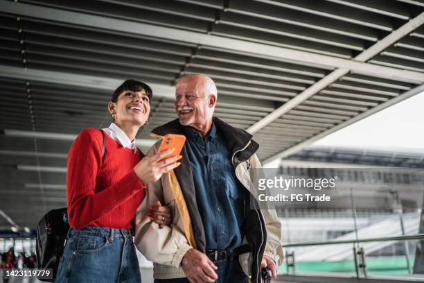 granddaughter and grandfather using the mobile phone in the subway - generation gap stock pictures, royalty-free photos & images