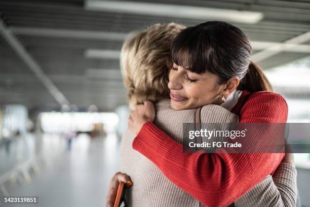 granddaughter leaving and embracing granddaughter in a subway station or airport - family airport stock pictures, royalty-free photos & images
