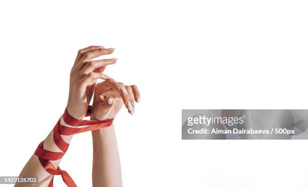 female hands tied with a red satin ribbon human trafficking and abuse - servidão imagens e fotografias de stock