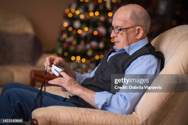 senior man with oximeter on his finger - christmas treat stock pictures, royalty-free photos & images