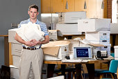 Man in an office over flowing with paperwork
