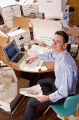 Man in an office over flowing with paperwork