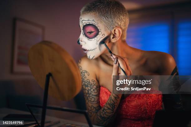 young woman doing make-up for day of the dead celebration - sugar skull stock pictures, royalty-free photos & images