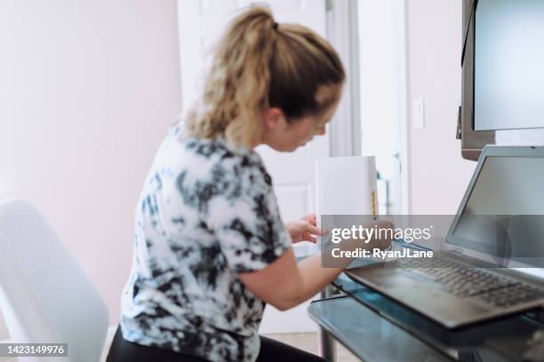 woman connecting router in home office - modem stockfoto's en -beelden