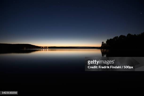 scenic view of lake against clear sky at night - väder stock pictures, royalty-free photos & images