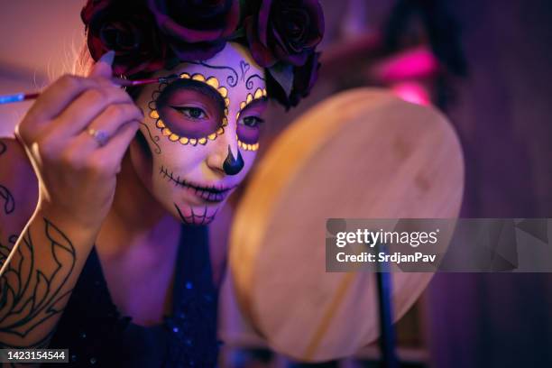 young woman doing make-up for day of the dead celebration - sugar skull stock pictures, royalty-free photos & images