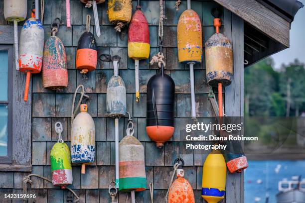 lobster buoys hanging on the side of a fishing hut in bass harbor, mount desert, maine - nautische ausrüstung stock-fotos und bilder
