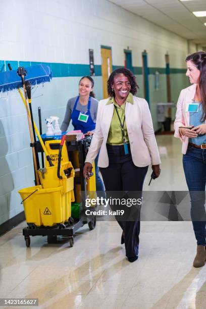 teachers and janitor walking thru school corridor - school caretaker stock pictures, royalty-free photos & images