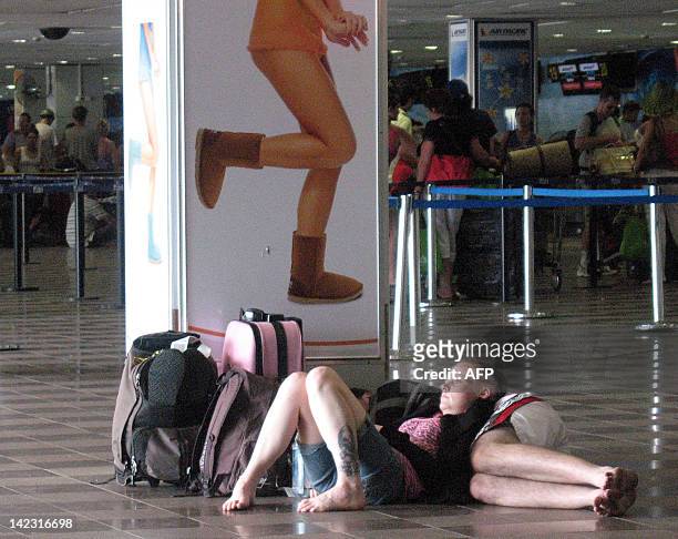 Travellers sleep on the floor of Nadi International Airport after flood waters caused flight cancellations to Fiji's main island of Viti Levu on...