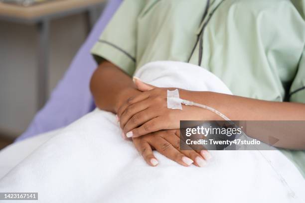 close up iv drip on patient hand - hospital bed with iv stock pictures, royalty-free photos & images