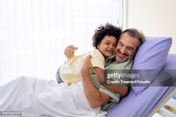 son visits father in law at the hospital - injured man in hospital bed stockfoto's en -beelden