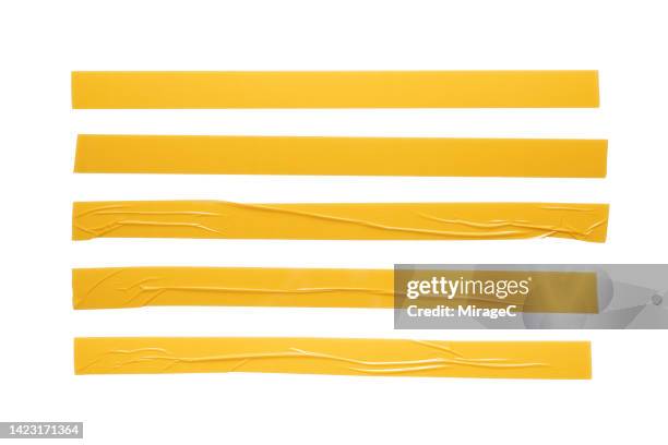 yellow plastic adhesive tape long stripes isolated on white - cinta adhesiva fotografías e imágenes de stock