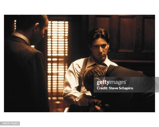 American actor Tom Rosqui watches as Richard S Castellano kisses the hand of Al Pacino in a scene from the film 'The Godfather' , New York, New York,...