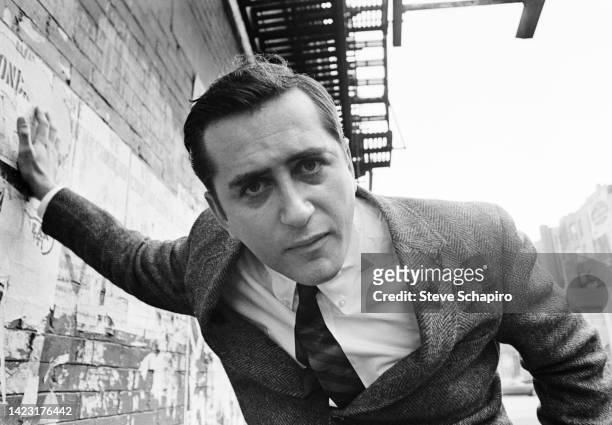 Portrait of American film director and actor Robert Downey Sr as he stands, one hand on a wall, on an unspecified street, New York, New York, 1967.