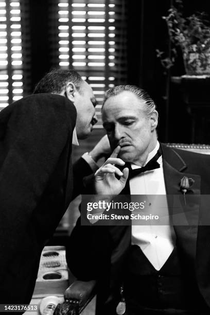 Italian actor Salvatore Corsitto whispers in the ear of American actor Marlon Brando in a scene from the film 'The Godfather' , New York, New York,...