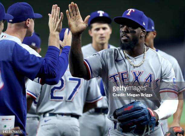 Adolis Garcia of the Texas Rangers high fives teammates after defeating the Miami Marlins during game one of a doubleheader at loanDepot park on...