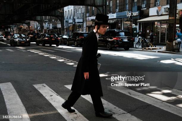 An orthodox Jewish boy walks down a street outside of a yeshiva school in Borough Park on September 12, 2022 in the Brooklyn borough of New York...