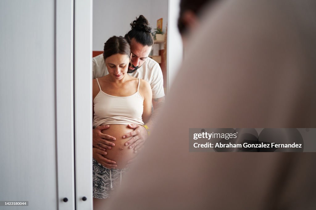 Pregnant woman and her partner embracing.