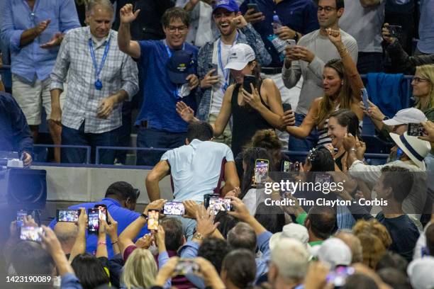 September 11: Spectators film Carlos Alcaraz of Spain climbing into the stand to visit coach Juan Carlos Ferrero and his team after his victory...