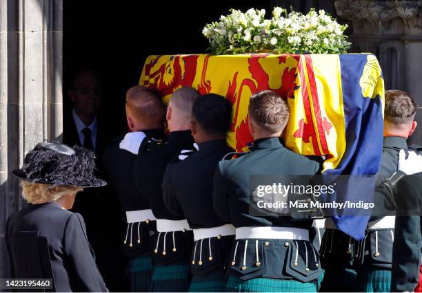 Camilla, Queen Consort looks on as Queen Elizabeth II's coffin, draped in the Royal Standard of Scotland, is carried into St Giles' Cathedral for a...