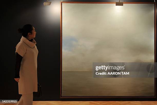 Woman walks next to Gerhard Richter's 'Seestuck ' at a media preview in Hong Kong on April 2, 2012. 'Seestuck ' is expected to fetch an estimated...