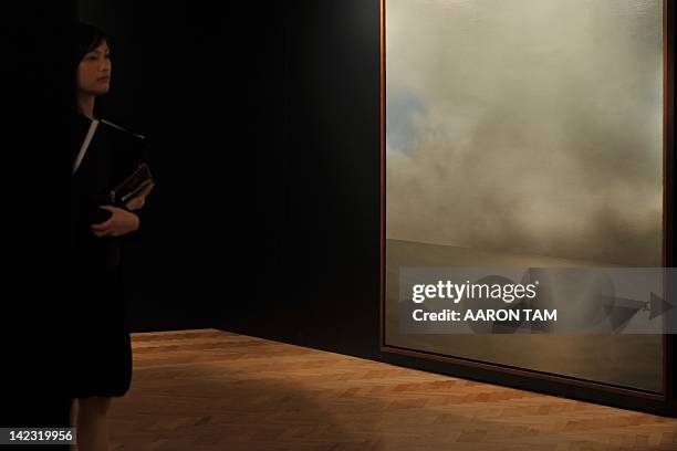 Christie's auction house staff member stands next to Gerhard Richter's 'Seestuck ' at a media preview in Hong Kong on April 2, 2012. 'Seestuck ' is...