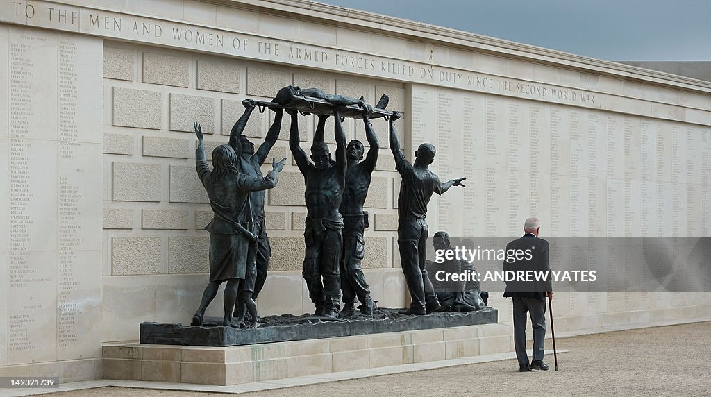 A man walks past a memorial wall listing