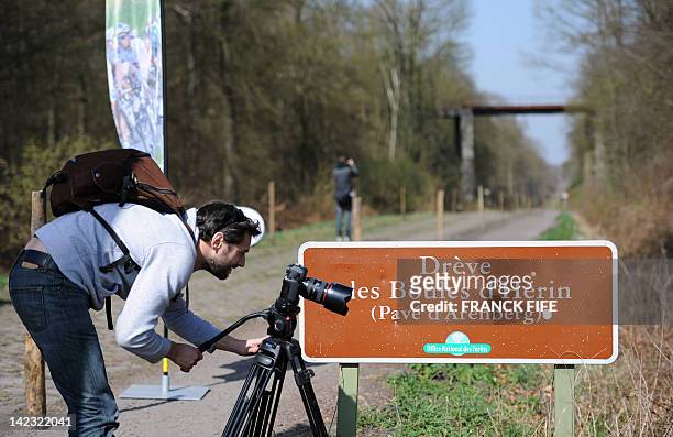 Journalist films on the Arenberg trench on the route of Paris-Roubaix cycling race on April 2, 2012 in Arenberg, northem France. Twenty-five teams...