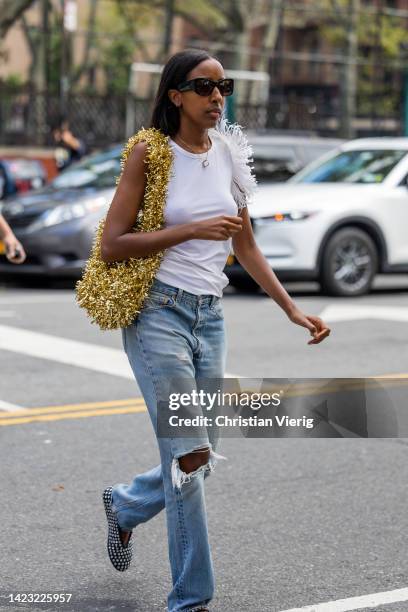 Guest wearing golden bag, ripped denim jeans outside Maryam Nassir Zadeh on September 12, 2022 in New York City.