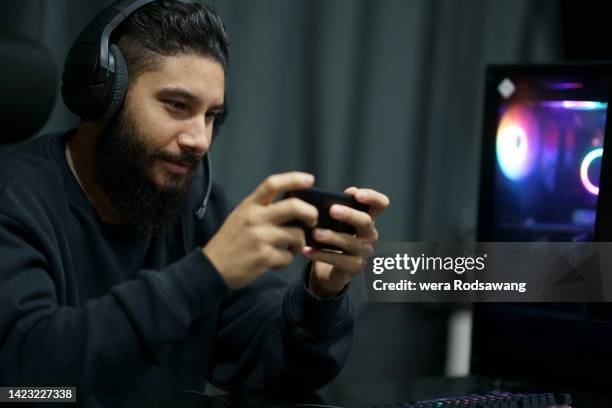 gamer playing online game on mobile phone - mobile game stock pictures, royalty-free photos & images