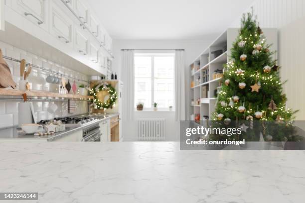 empty white marble surface and blurred kitchen background with christmas tree - christmas kitchen counter stock pictures, royalty-free photos & images