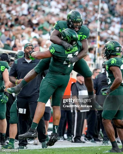 Simeon Barrow of the Michigan State Spartans and Derrick Harmon of the Michigan State Spartans celebrate against the Akron Zips during the third...