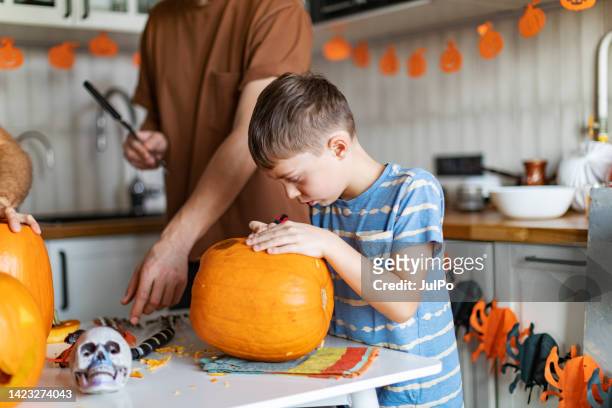 father and son carving pumpkins for halloween party - 468303816 stock pictures, royalty-free photos & images