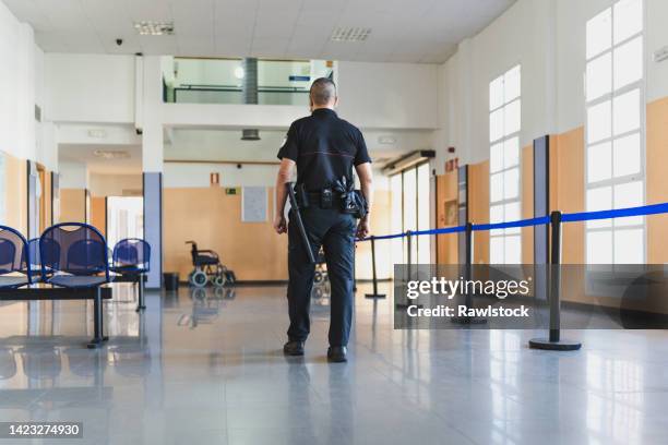 a security officer with his back turned at the hospital - security guard stock pictures, royalty-free photos & images