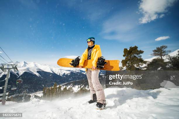 giovane donna adulta che fa snowboard in montagna - wintersport foto e immagini stock