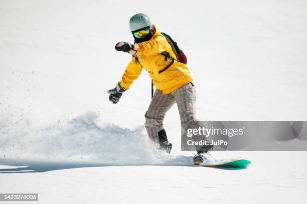 young adult woman snowboarding in mountains - snowboarder stock pictures, royalty-free photos & images