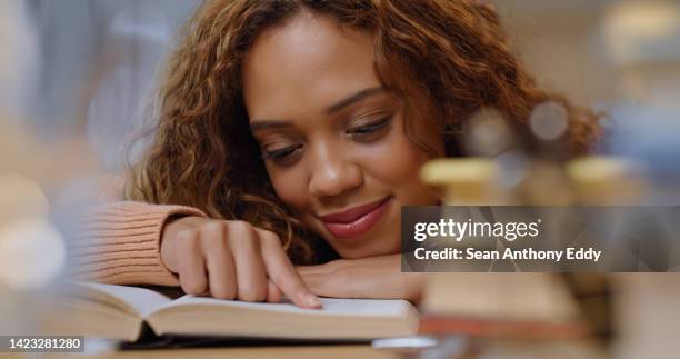 learning, study and book reading university woman student from spain in a library studying. education books of college scholarship pupil happy and relax doing research for school report with a smile - beneficiary stockfoto's en -beelden
