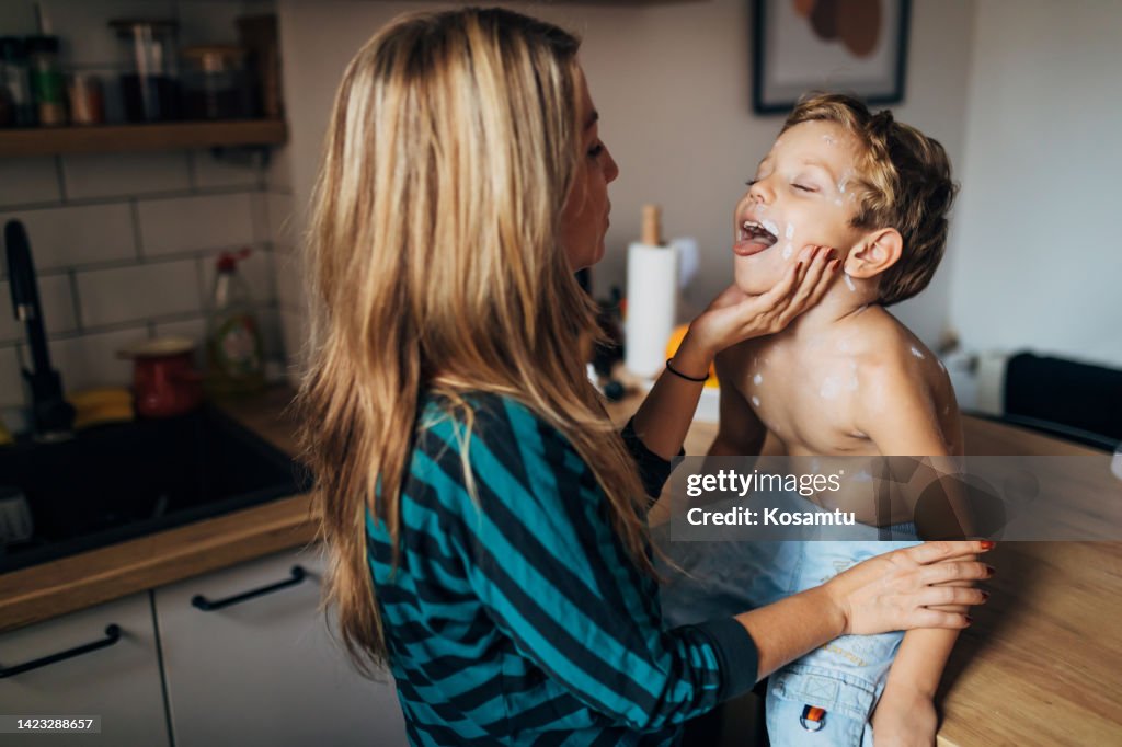 A mother is checking her cute little son for a sore throat
