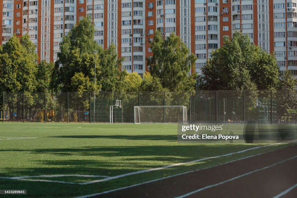 Empty Football Field Against Residential Building
